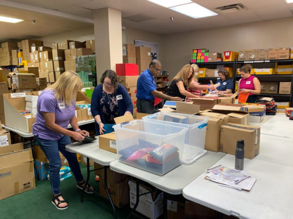 volunteers sort and pack school supplies